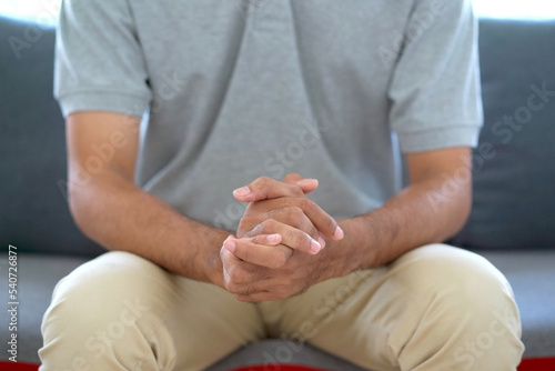 stressful Asian man sitting alone in living room. A man worried and concerned about something.