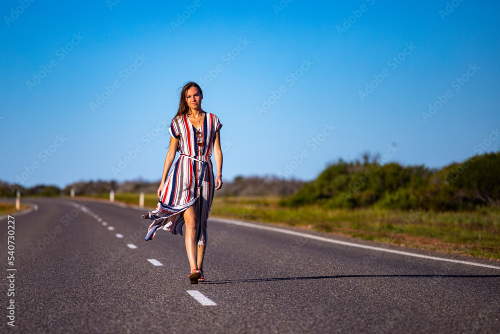 a beautiful long-haired girl in a long dress walks along a road in the desert in western australia, a beautiful girl lost in the middle of nowhere a beautiful long-haired girl in a long dress walks along a road in the desert in western australia, a beautiful girl lost in the middle of nowhere