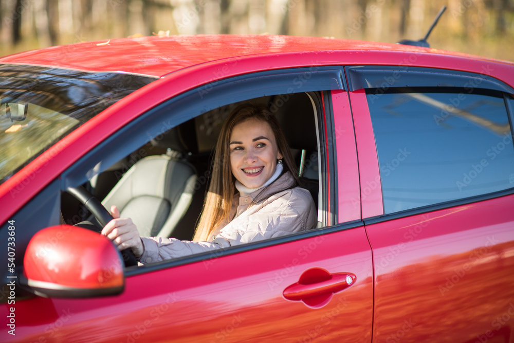 brunette girl travels in autumn in a red car, the concept of travel and autumn holidays, vacation