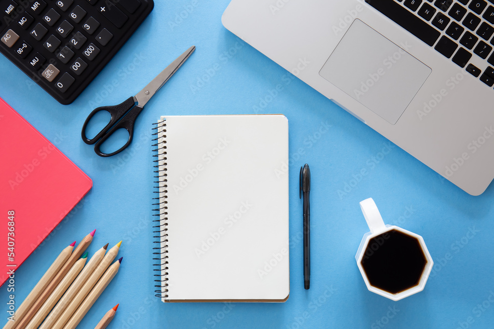 Flat lay, notepad, laptop and stationery on blue background. Flat lay, notepad, laptop and stationery on blue background.