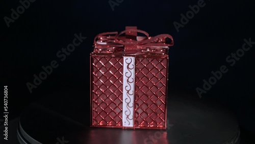 Gift red box slowly rotates on a black background
