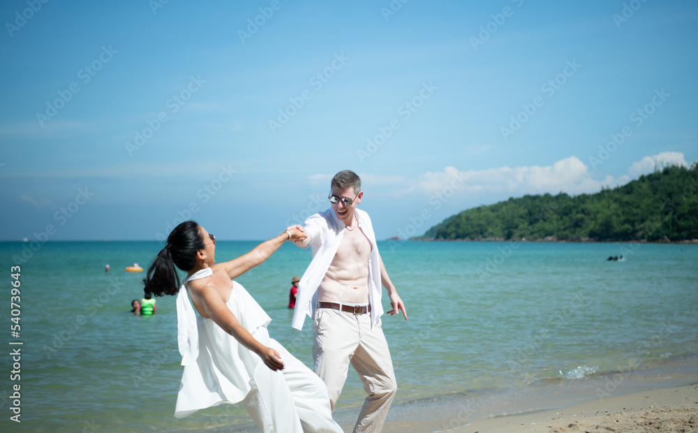 Interracial couple with the joy of traveling to the beautiful blue sea like the paradise Interracial couple with the joy of traveling to the beautiful blue sea like the paradise