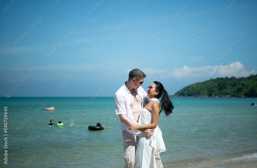 Interracial couple with the joy of traveling to the beautiful blue sea like the paradise Interracial couple with the joy of traveling to the beautiful blue sea like the paradise