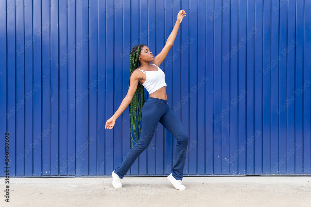 Young dynamic black woman dancing on street Young dynamic black woman dancing on street