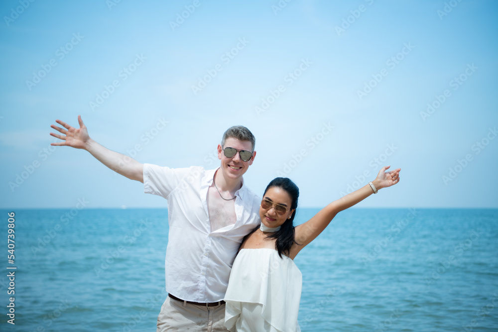 Interracial couple with the joy of traveling to the beautiful blue sea like the paradise Interracial couple with the joy of traveling to the beautiful blue sea like the paradise