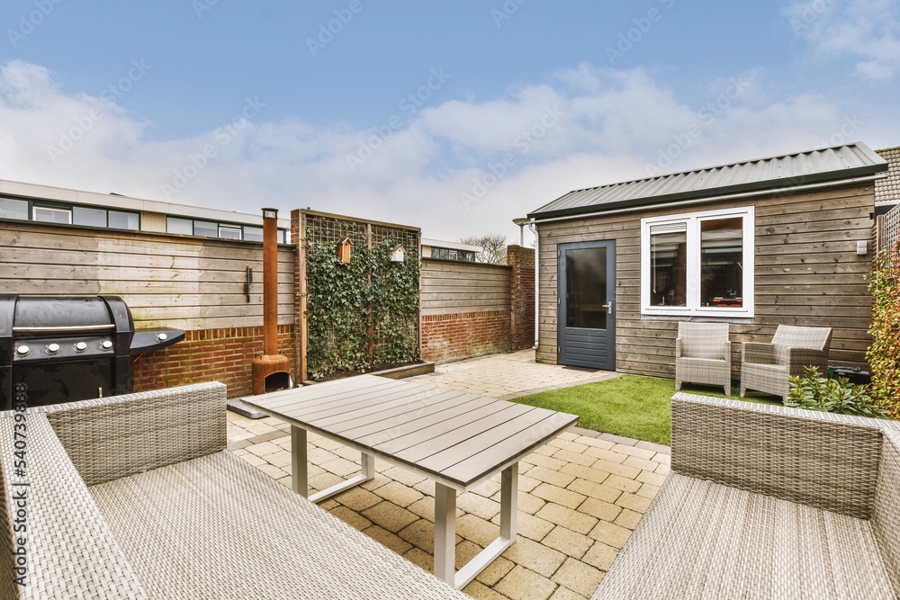 Backyard of house with wooden seat under near shed Backyard of house with wooden seat under near shed