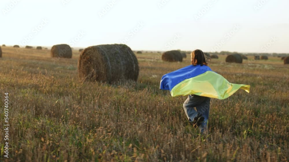Little Girl with flag of Ukraine running on the field. Stop war between Russia and Ukraine, power of Ukraine, patriotism. Ukrainian girl with a blue-yellow flag against the sky Little Girl with flag of Ukraine running on the field. Stop war between Russia and Ukraine, power of Ukraine, patriotism. Ukrainian girl with a blue-yellow flag against the sky