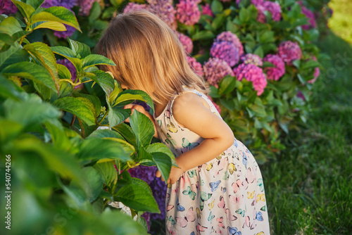 Adorable child dressed as a butterfly smelling flowers © Виктор Осипенко