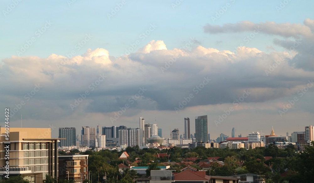 clouds over city, low-rise buildings in the foreground