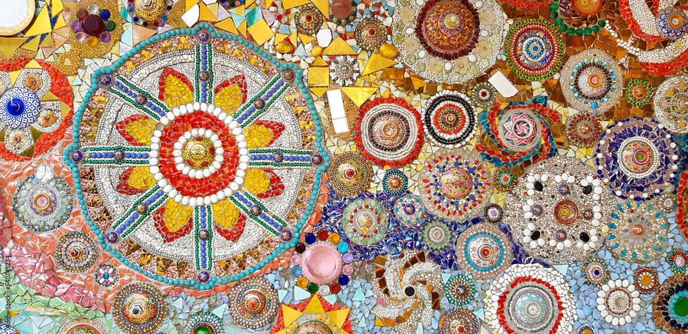 Colorful wall decorated with multicolor stone, gravel and gem for background at Wat Phra That Pha Son Kaew. Abstract of art design with broken tile for wallpaper.