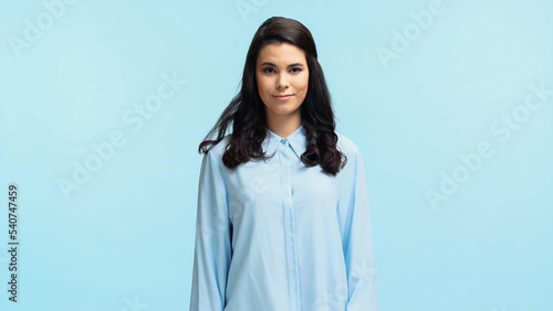 happy young woman in shirt looking at camera isolated on blue
