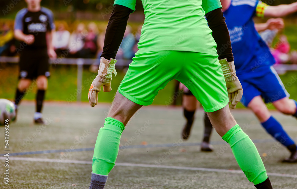 Goalkeeper in action. Rear view of Soccer Football Goalkeeper Goal on the Pitch During Match. 
