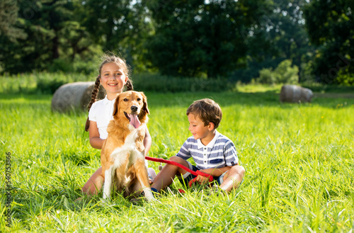 Cute siblings and their dog playing together outdoor
