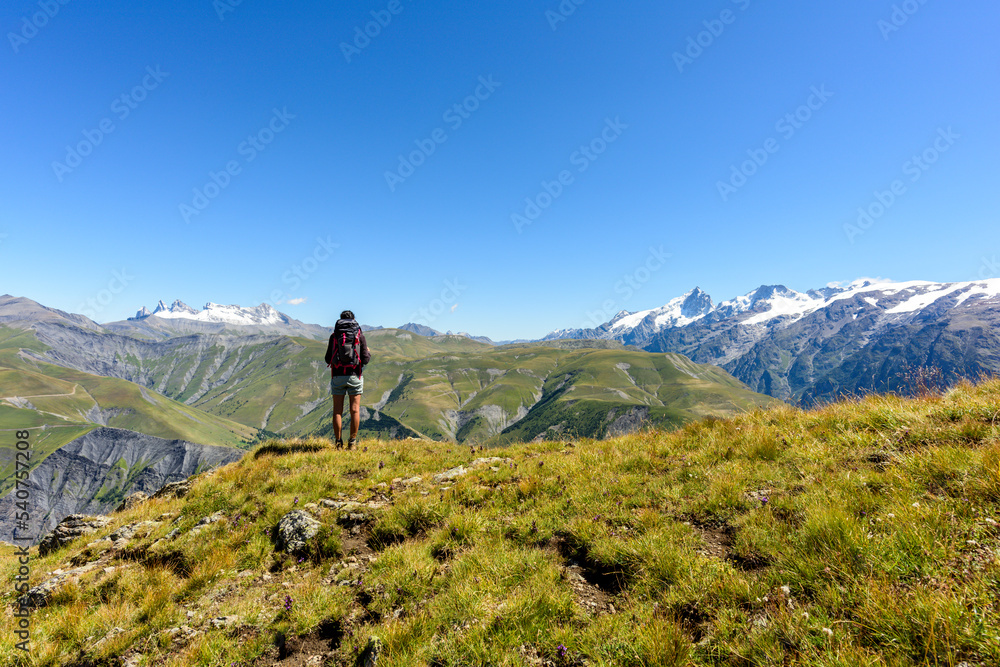 Hiker enjoying the scenic view at the top of a mountain during summer, French Alps