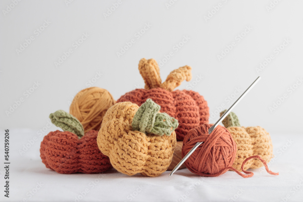 Cute crochet knitted yellow and orange pumpkins on white background