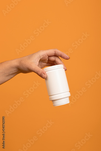 upside down empty white plastic sweetener bottle in hand. the concept of running out of dietary supplements