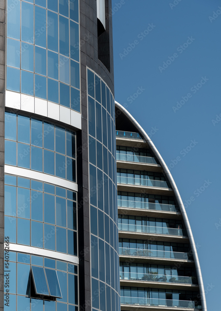 Modern glass and steel futuristic office building against blue sky, Luxury office energy efficient  tower