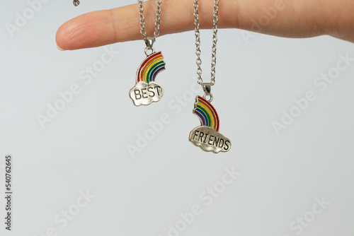 two pendants with silver clouds and halves of the rainbow with the inscription best friends on the palm