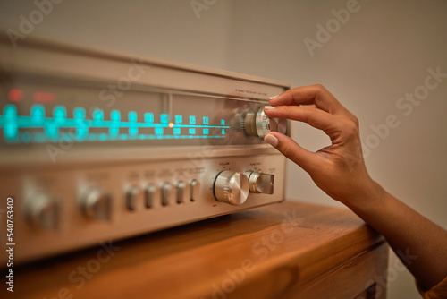 Anonymous woman adjusting knob on vintage receiver