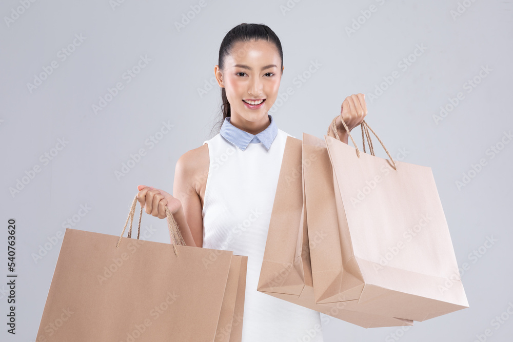 Beautiful Attractive Asian Woman smile and holding luxury shopping bags  feeling so happiness and enjoy with black Friday sale in Shopping  mall,isolated on white background. Shopping Lifestyle Concept Stock Photo