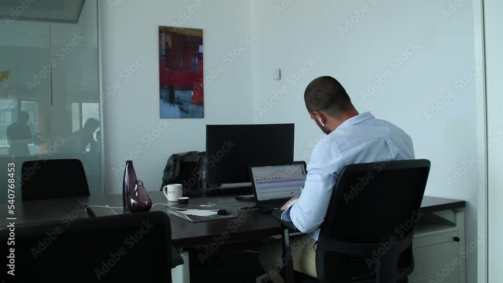 short-haired man works in his office while listening to a headset. short-haired man works in his office while listening to a headset.