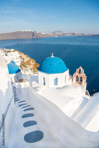 Beautiful Oia town on Santorini island  Greece. Traditional white architecture and greek orthodox churches with blue domes over the Caldera  Aegean sea. Scenic travel