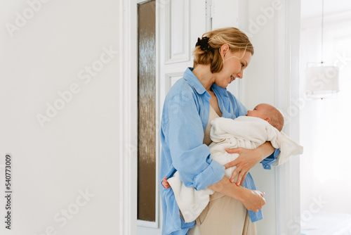 White blonde woman holding her baby while resting at home