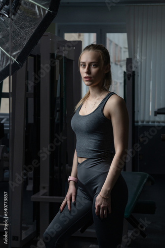 Portrait of a young beautiful blonde girl in sportswear in the gym.
