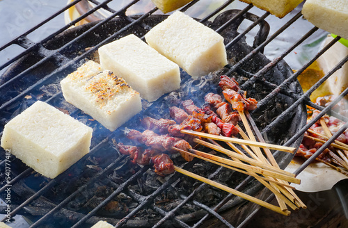 Sate maranggi or satay maranggi and Jadah bakar, uli bakar or grilled sticky rice, a traditional javanese cake made from glutinous rice with grated coconut grilled on the satay grill.  photo