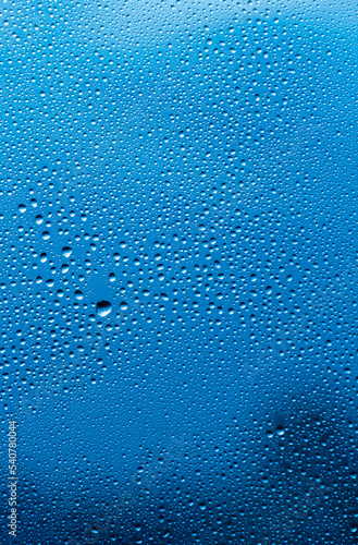 Rain drops on the glass. Beautiful blue sky. Sky background. Evening. vertical frame .