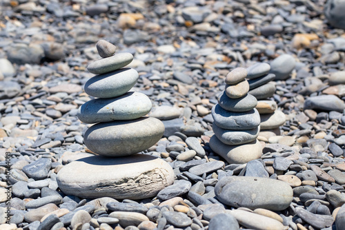 Pebbles on the seashore are stacked in a pyramid. Rest and relaxation  a sense of balance.