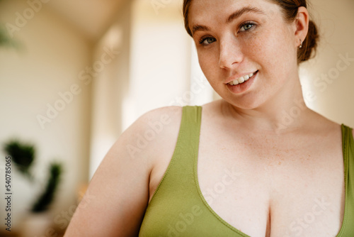 Ginger young woman wearing sportswear smiling after yoga practice