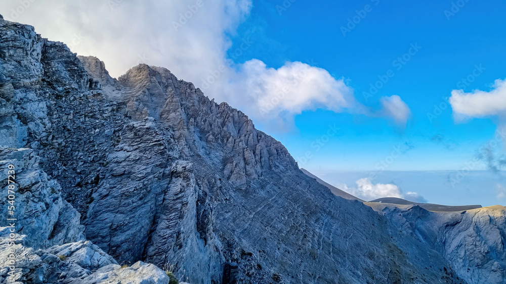 Climbing on mystical foggy hiking trail leading to Mount Olympus (Mytikas, Skala, Stefani, Skolio), Mt Olympus National Park, Macedonia, Greece, Europe. Scenic view of cloud covered cliffs and ridges
