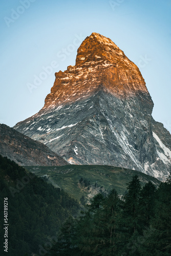 Photo of the Matterhorn from Zermatt, Switzerland at sunrise while the tip is lit by the sun © Matthew
