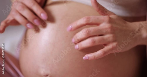 Wallpaper Mural pregnant woman touching belly and sitting on the bed Torontodigital.ca