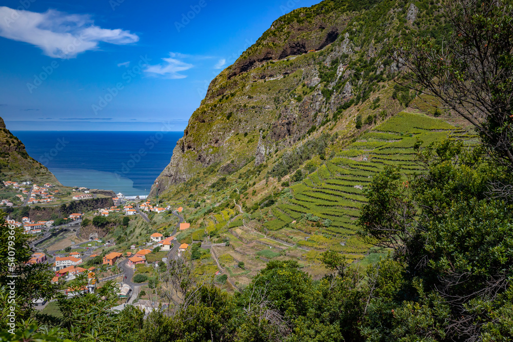 Krajobraz górski z widokiem na ocean. Portugalskie krajobrazy z niebieskim niebem i widokiem na lazurowy ocean na wyspie Madera. Podróże i wakacje na Maderze.	