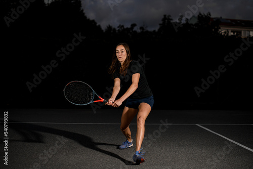 view on woman tennis player on the outdoor tennis court with racket in her hand. © fesenko