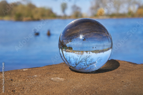View of tree and lake in Winter park through a crystal ball