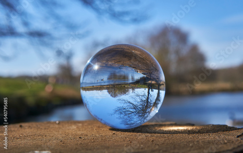 View of tree and lake in Winter park through a crystal ball
