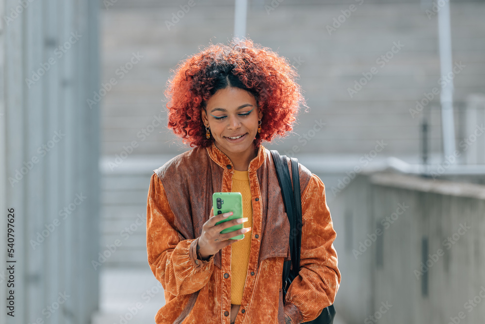 Fototapeta premium young afro american woman with mobile phone in the street