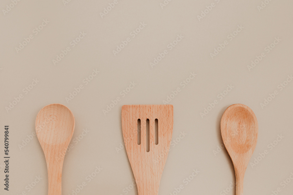 Three different wooden spoon on beige paper background. Copy space, flat lay photo. Three different wooden spoon on beige paper background. Copy space, flat lay photo.