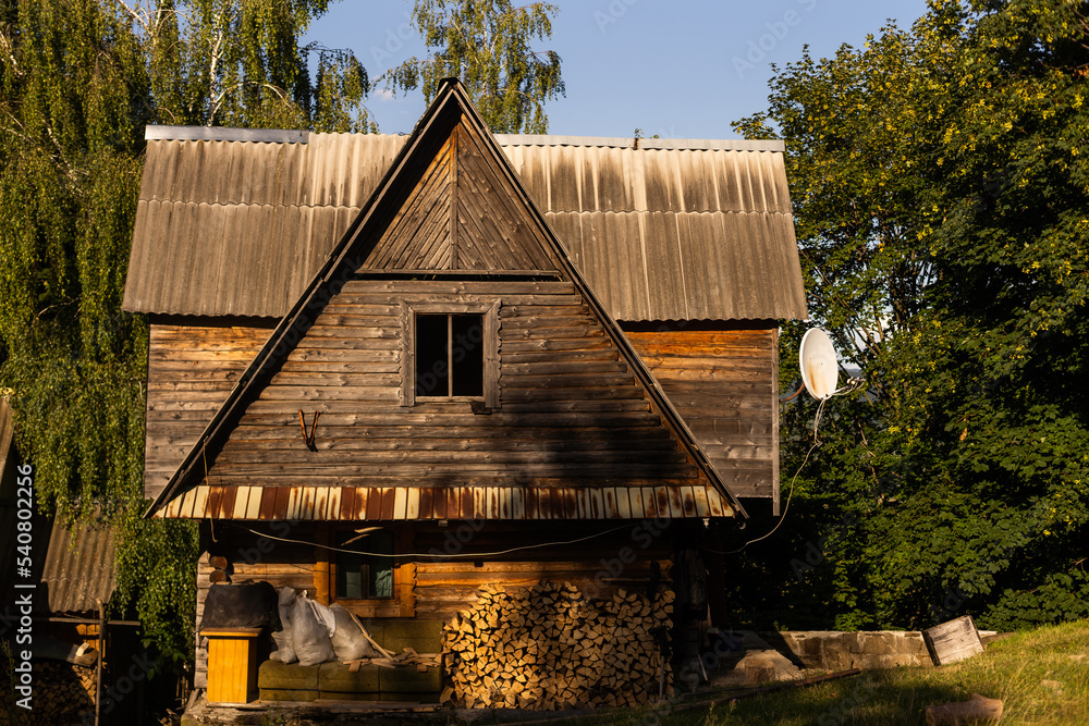 Wooden house with a roof near a clearing in the forest Wooden house with a roof near a clearing in the forest