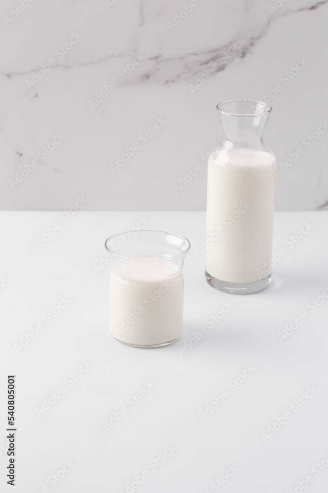 glass and jug with milk on white background glass and jug with milk on white background
