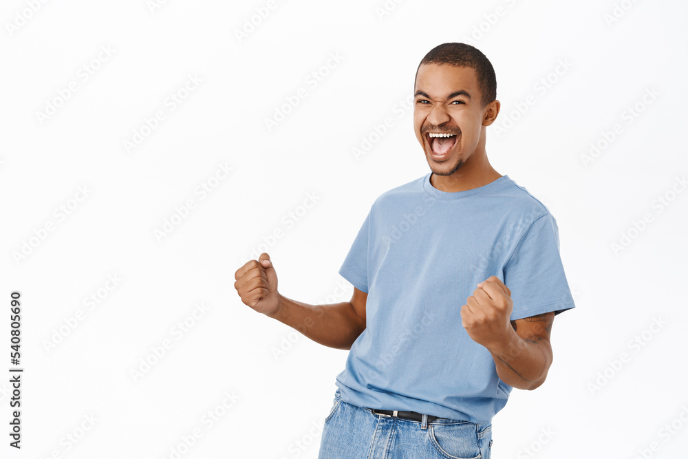 Win, triumphing people. Happy arab man cheering, celebrating victory, shouting of joy, standing over white background Win, triumphing people. Happy arab man cheering, celebrating victory, shouting of joy, standing over white background