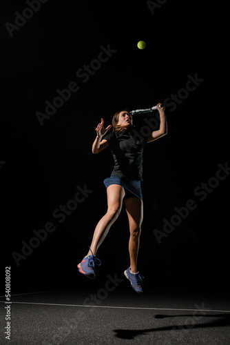great shot of female tennis player with tennis racket in her hand bouncing to hit the tennis ball. © fesenko