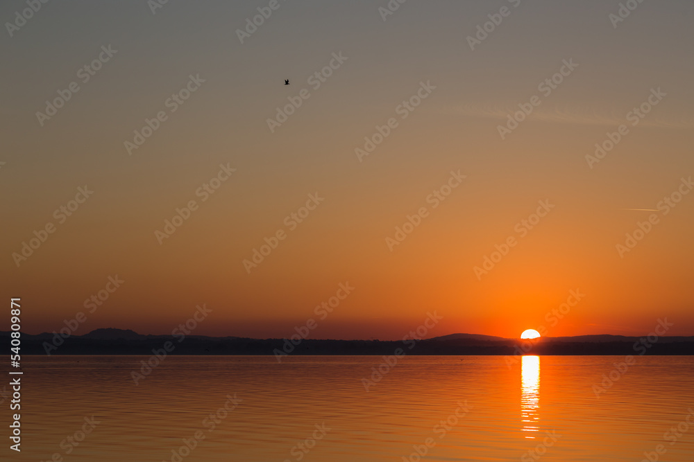 Distant and minimalistic sunset on a lake Distant and minimalistic sunset on a lake