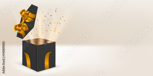 Festive illustration with open black gift box with golden ribbons and bow. Pieces of serpentine and rays of light fly out of it