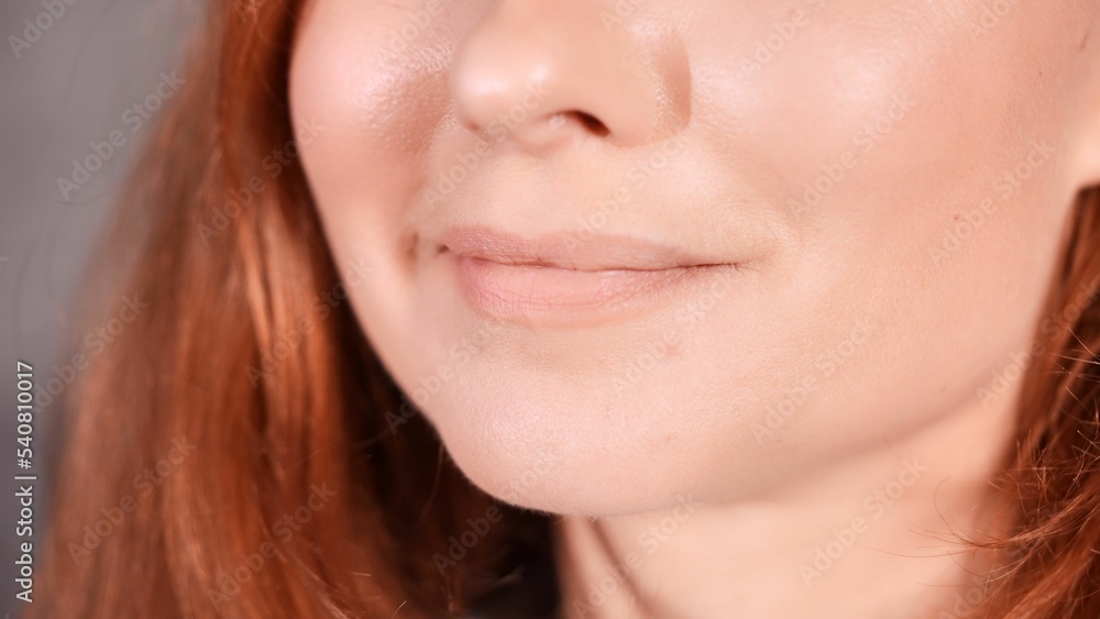 Obraz premium Closeup shot of a smile of a Caucasian female with red hair.
