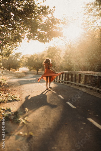 Εκτύπωση καμβά Teen girl twirling her red dress on a trail in sunset