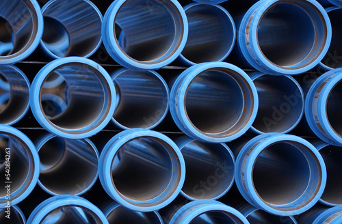 Rohre aus Plastik für Frischwasser. Sie warten auf einer Baustelle, dass sie einige neue Häuser versorgen dürfen. Sie sind staubig. Sie bilden ein regelmäßiges, doch leicht psychedelisches Muster. 